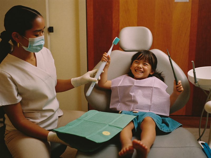 A young child smiling in the chair at an orthodontic visit